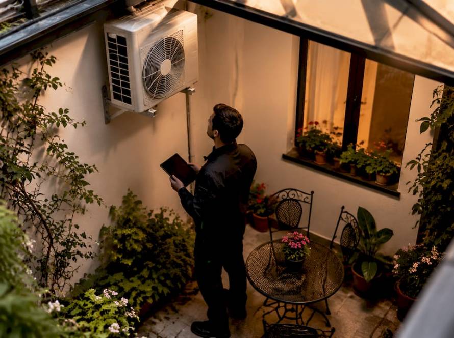 Un especialista revisando el aire acondicionado en el patio interior